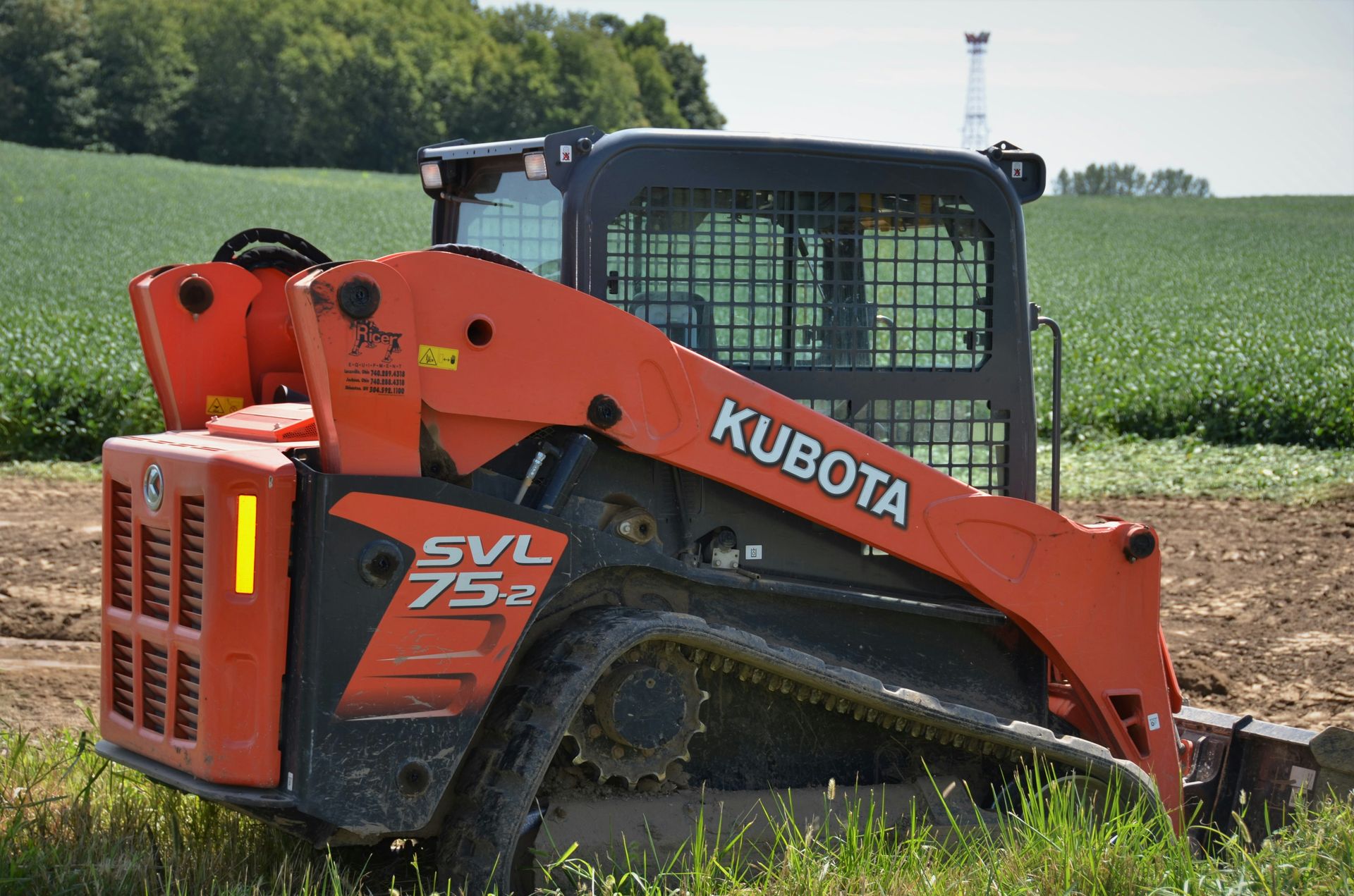 orange and black tractor on green grass field during daytime